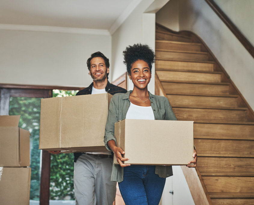 Couple Moving Boxes Into Home